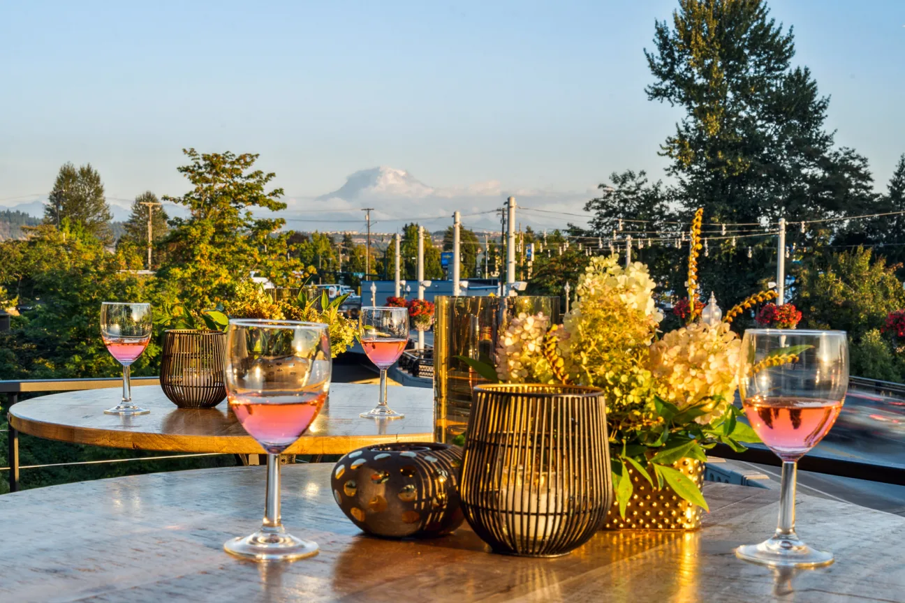 A table with wine glasses and vases on it